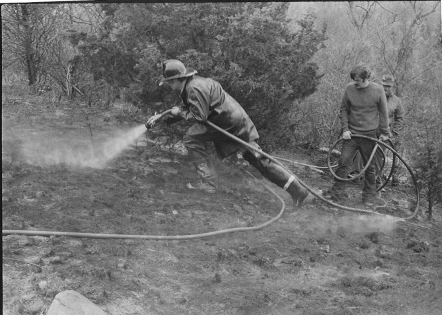 From the Archives: Grass Fire in Indian Hills.  From The Westerly Sun 4/29/74.  Caption reads: &quot;Firemen from the Dunn's Corners Department attacking a brush and grass fire that burned about 1/2 acre at the east edge of Indian Hills at Dunn's Corners early yesterday afternoon.  Chief Henry M. Morris said the fire was apparently started by someone smoking or playing with matches.  A packet of discared matches was found in the fire area, he said.  Firemen responed to the alarm in three trucks and halted the flames in twenty minutes.&quot;